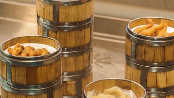 Four wooden barrels with metal bands, each containing different food items.