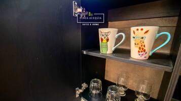 A shelf with two mugs and three glasses.
