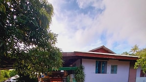 A house with a red roof, a white exterior, and a paved driveway. - Tapuhere Lodge (Huahine)