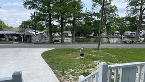 A concrete pathway leading to a grassy area with a bench and a mailbox.