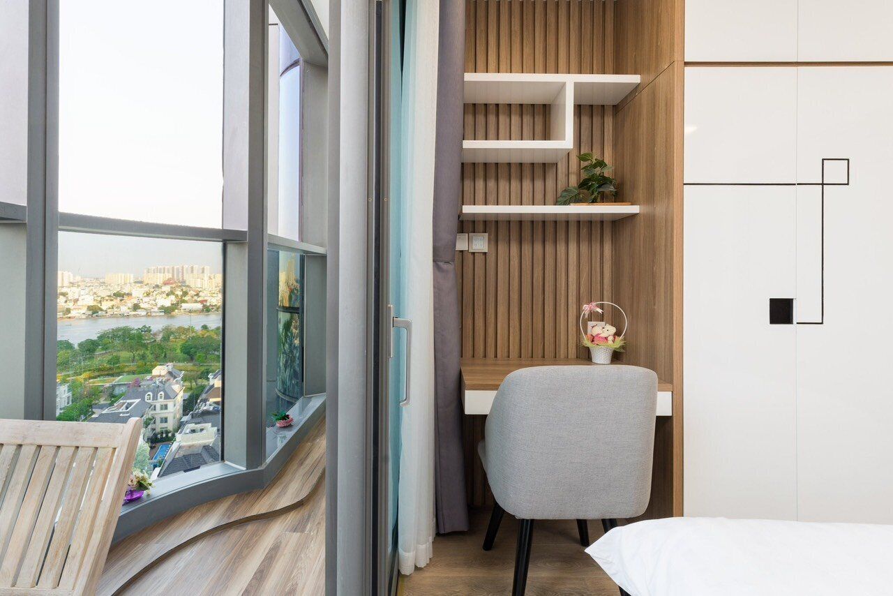 Une chambre moderne avec une grande fenêtre, un bureau, une chaise et un lit.