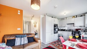A modern apartment with a living room, kitchen, and dining area.