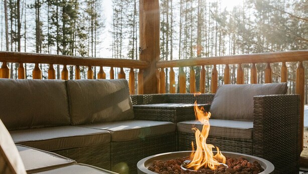 A cozy outdoor seating area with a fire pit, cushioned seating, and a view of tall trees. - Steps from the lift, quick pedal to the trails, short drive to golf.  (Kimberley)