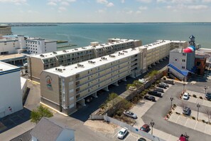 A multi-story hotel with a parking lot, a view of the sea, and a distinctive building with a colorful dome. - Ocean City Bayside Condo, Newly Renovated (Ocean City)