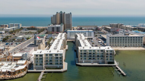 Un hotel frente al agua con varios edificios conectados por un canal, que ofrece vistas del océano y la playa contigua.