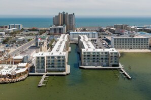 Ein Hotel am Wasser mit mehreren Gebäuden, die durch einen Kanal verbunden sind, mit Blick auf den Ozean und den angrenzenden Strand.