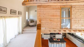 Un intérieur en bois comprenant une cuisine, un coin repas et un escalier.