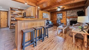 A wooden interior with a bar area, seating, and a fireplace. - Woodfern Retreat-Pet Friendly EasyCentral Location (Maggie Valley)