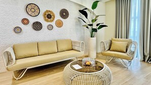 A modern living room with a sofa, two armchairs, a round coffee table, and decorative wall art. - Ondus Boracay (Boracay Island)