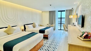 A hotel room with two beds, a desk with snacks, a TV, and a balcony with curtains. - Ondus Boracay (Boracay Island)