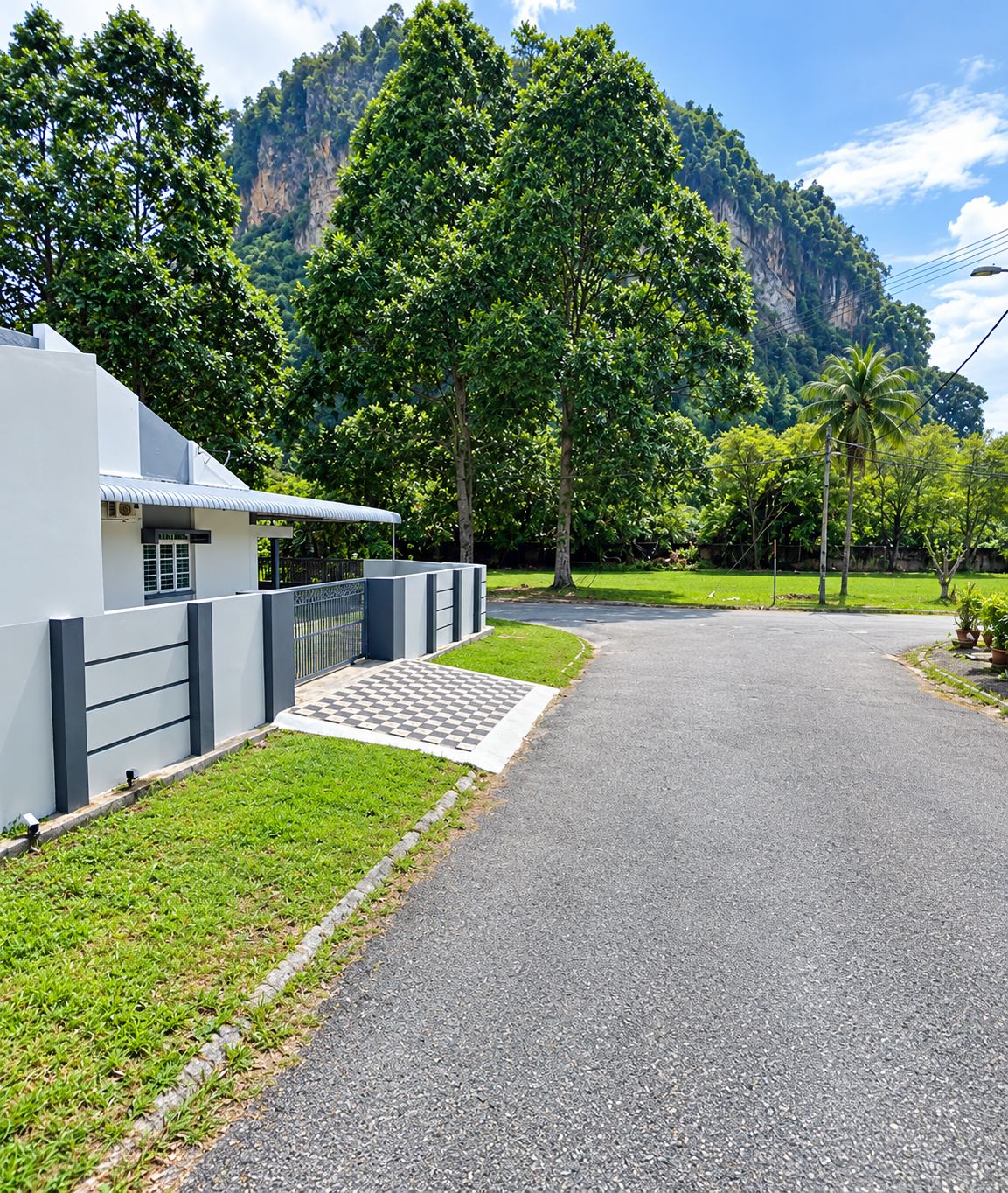 A paved driveway leading to a modern building with a white facade and a covered entrance.