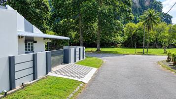A paved driveway leading to a modern building with a white facade and a covered entrance.