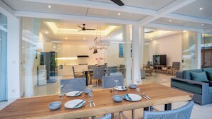 Un comedor moderno con una mesa de madera dispuesta para cuatro personas, rodeada de sillas de mimbre.
