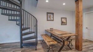 A staircase with metal railings, a wooden bench, and a table with a bowl of fruit. - 3BR with Mountain Views on FREE Bus Line (Breckenridge)