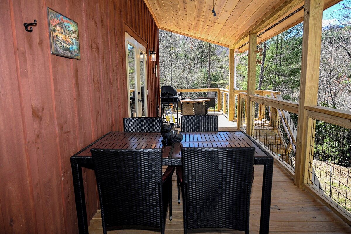 Ein überdachter Außenbereich mit Holzterrasse, Korbmöbeln und Grill.