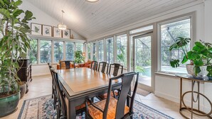 A spacious dining area with a large wooden table, multiple chairs, and potted plants. - 10 Mi to Disney World, Lakeside Orlando Getaway (Orlando)