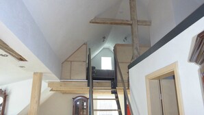 A loft bedroom with a wooden ladder, a window, and a door. - Apartment 'Stuifenblick' with Mountain View, Private Garden and Wi-Fi (Waldstetten)