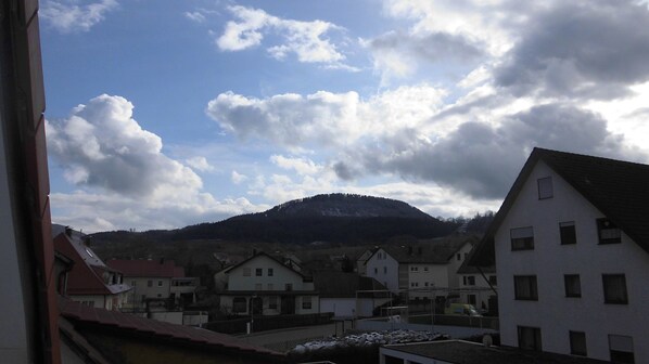 A residential area with houses, a mountain, and a partly cloudy sky.
