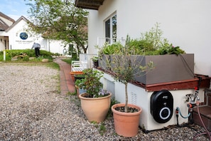 A hotel entrance with a gravel path, potted plants, and a water feature. - Apartment 'Wohnung 2' with Private Terrace, Shared Garden and Wi-Fi (Hohwacht (Ostsee))