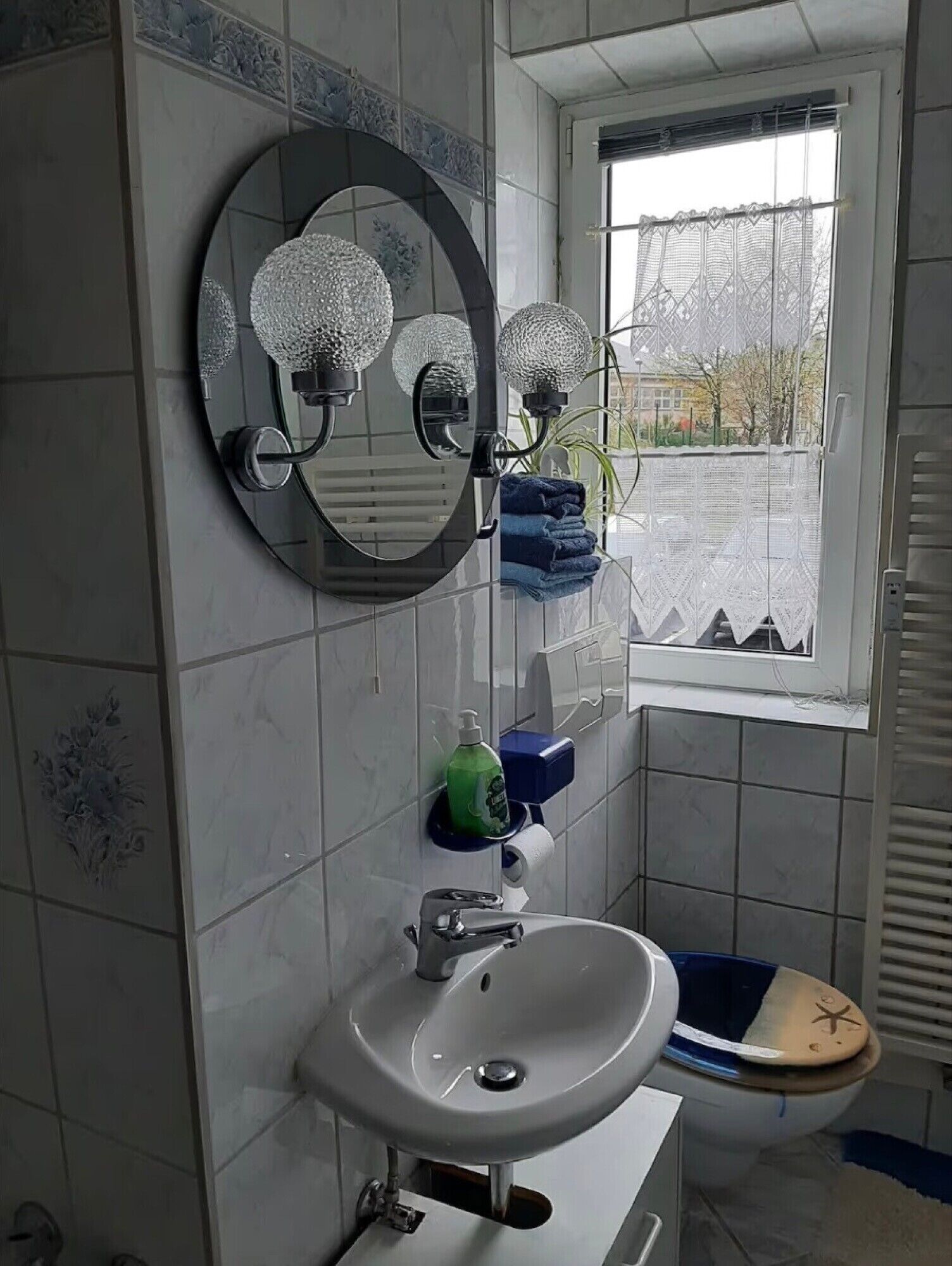 Une salle de bain avec un lavabo, un miroir et des toilettes.
