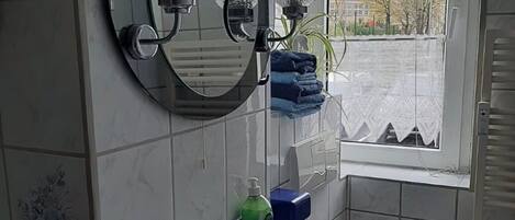 Une salle de bain avec un lavabo, un miroir et des toilettes.