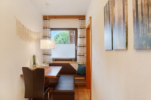 A dining area with a bench, table, and chairs.