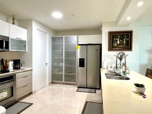 Enjoy cooking in this well-equipped kitchen with a refrigerator, oven, microwave, and sink.