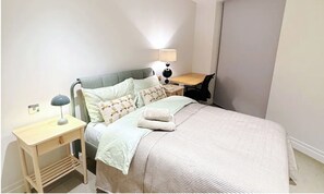 Cozy retreat with a single bed, bedside table, and comfortable chair, perfect for a relaxing stay.