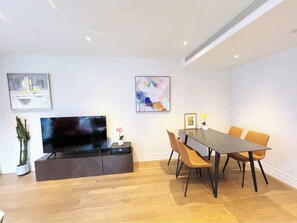Relax in this stylish living space with a flat-screen TV, dining area, and modern decor.