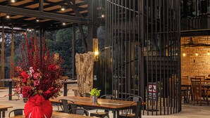 A modern interior with exposed beams, wooden tables, and metal chairs. - Sebayu Retreat Gopeng (Ipoh)
