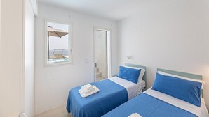 Una habitación de hotel con dos camas, una ventana y una puerta.