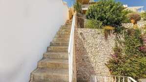 Una escalera de piedra que conduce a un edificio blanco con balcón.