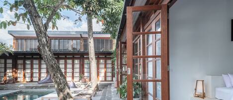 A modern house with a wooden exterior, a swimming pool, and a wooden deck.