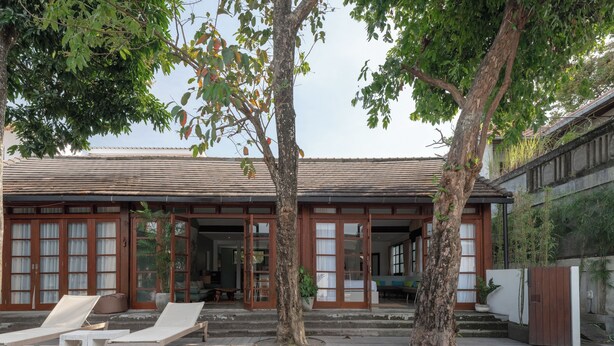 Ein traditionelles Haus mit einer Holterrasse, einem Schwimmbad und einem Garten.