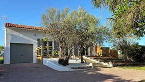 A modern house with a garage, a covered patio, and a gravel driveway. - Agréable Maison au Calme , Proche de la mer (Meursac)