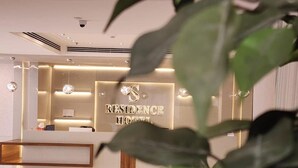En receptionsdisk med en skylt som visar texten "RESIDENCE HOTEL".