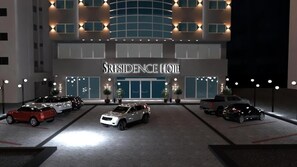 A hotel with a modern facade, multiple parking spaces, and a prominent entrance. - S.Resedance (Dammam)