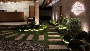 A modern outdoor area with a reception desk, a thatched roof, and a neon sign for 'CASMARA'. - Nadhibar Resort (Mahinog)