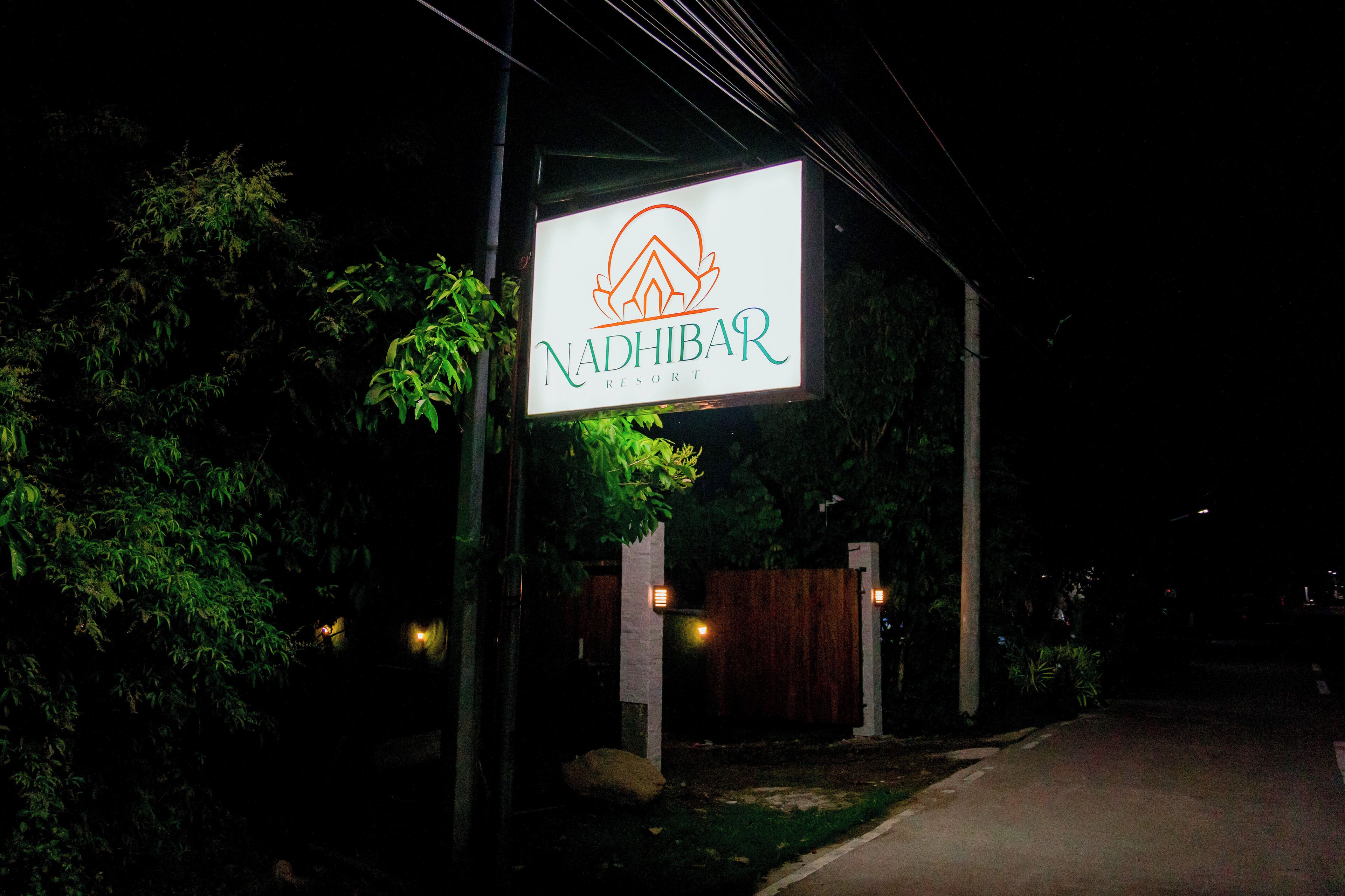 Une enseigne du Nadhibar Resort, de nuit.