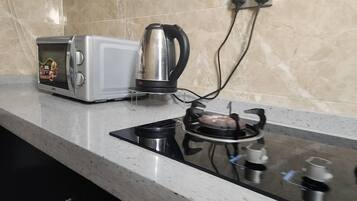 Una cocina con tostadora, hervidor y estufa a gas.