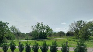 A grassy field with a fence and trees in the background. - Gîte Laurence 4/5 Personnes (Rogues)