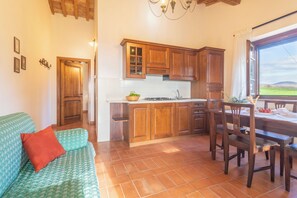 A cozy kitchen with wooden cabinets, a dining table, and a view of the outdoors.
