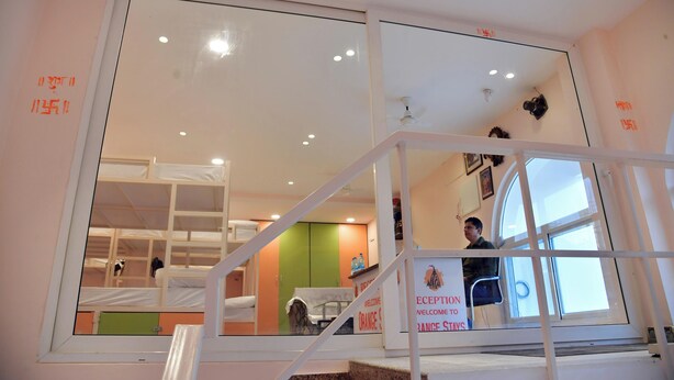 A hotel room with bunk beds, a staircase, and a welcome sign.