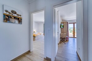 Een hotelkamer met een bed, een televisie en een balkon met uitzicht.