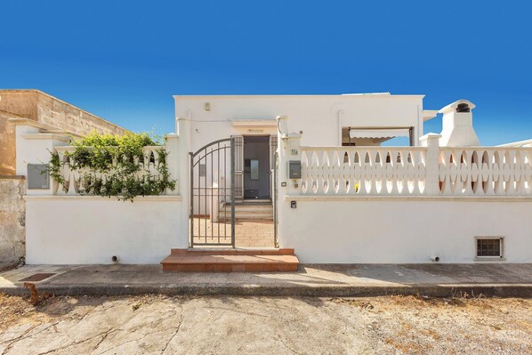 A white building with a gated entrance, a small window, and a chimney. - 3871 Villetta Anastasia by Barbarhouse (Manduria)
