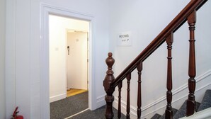 A staircase with wooden balusters leading to a room labeled 'ROOMS 20-22'. - Pebbles Guest house (Southampton)