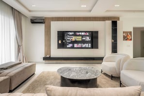 Deluxe Apartment | Living area | 50-inch LED TV with cable channels, Netflix, streaming services - George Residence Bayberry (Lekki)