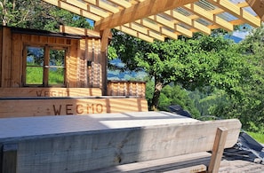 A wooden cabin with a pergola, a window, and the name 'WEGMO' on the side.