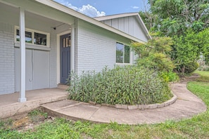 A single-story house with a front porch, a door, and a window.