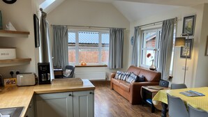 A cozy kitchen with a wooden countertop, a built-in oven, and a coffee maker. - Oiseval is a pet friendly cottage with magnificent views. (Fort Augustus)